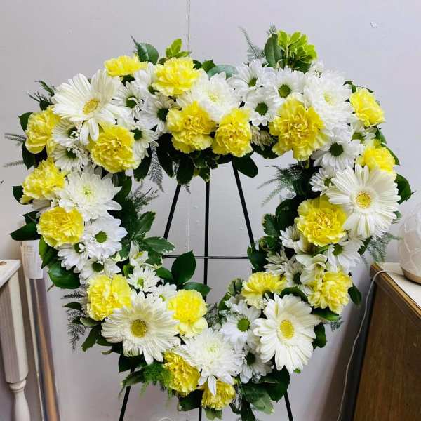 Heart-shaped floral wreath with white daisies and yellow carnations