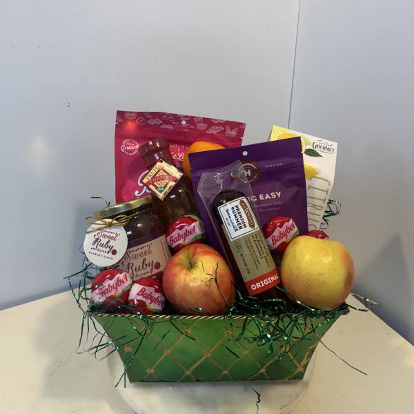 Gift basket with apples, citrus, and packaged snacks in a green container