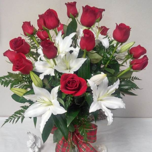 Bouquet of red roses and white lilies in a glass vase