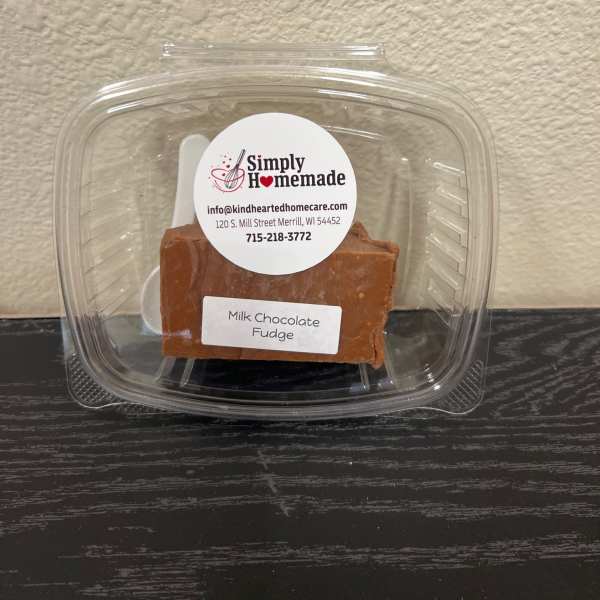 Plastic clamshell container holding a block of milk chocolate fudge