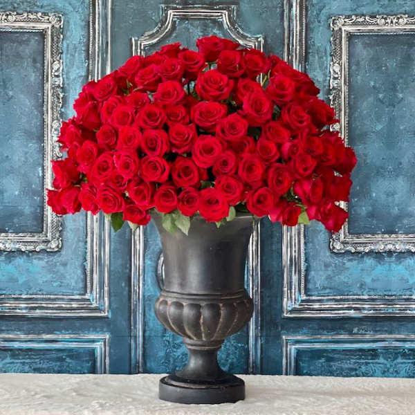 Large bouquet of red roses in a dark urn vase