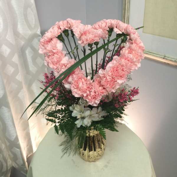 Pink carnation arrangement in a gold vase with white flowers