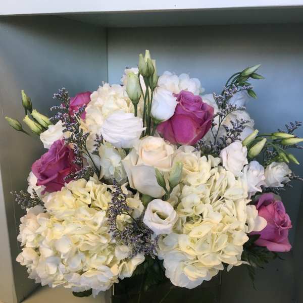 Bouquet of white hydrangeas and pink roses in a black vase