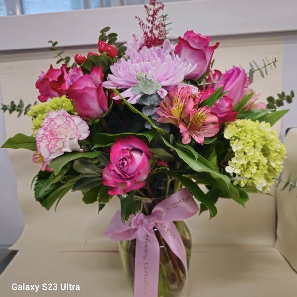 Pink and lavender bouquet in a glass vase with a ribbon