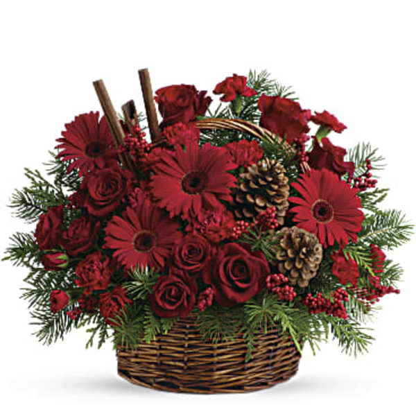 Red roses and gerbera daisies in a wicker basket with pinecones