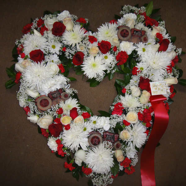 Heart-shaped floral wreath with red and white flowers and a red ribbon