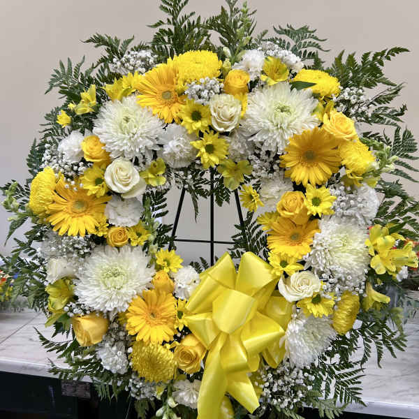 Yellow and white floral wreath with a large yellow bow