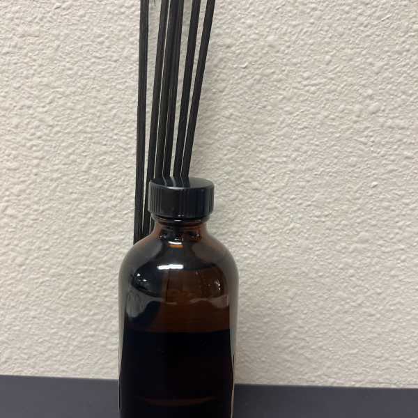 Amber glass bottle with black reed sticks