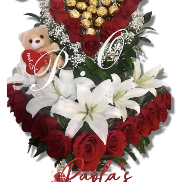 Heart-shaped bouquet of red roses, white lilies, and chocolates with a teddy bear