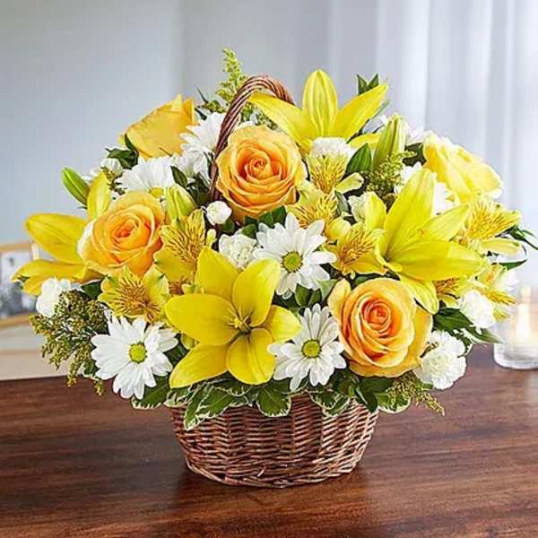 Yellow roses and lilies in a wicker basket with white daisies