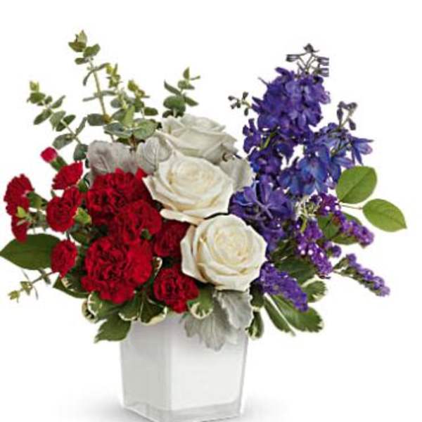 Bouquet of red and white roses with purple flowers in a clear vase