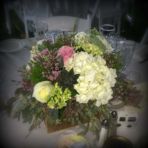 Large floral centerpiece with white and pink blooms in a low container