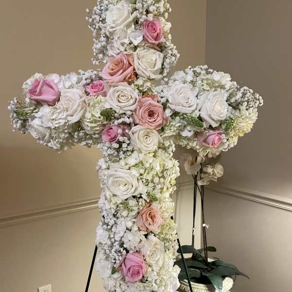 Large floral cross covered in white and pink roses