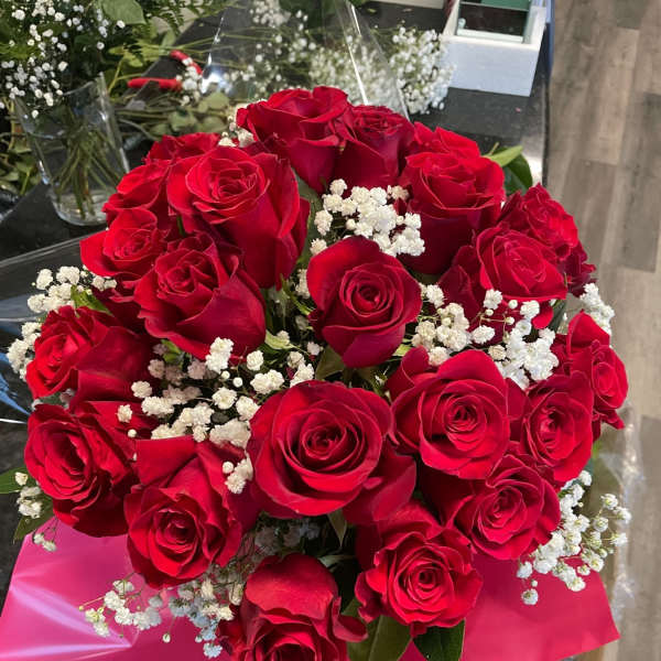 Bouquet of red roses with white baby's breath in pink wrap