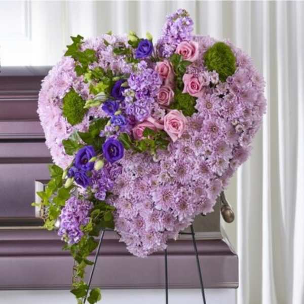 Heart-shaped floral spray with pink and purple flowers on an easel