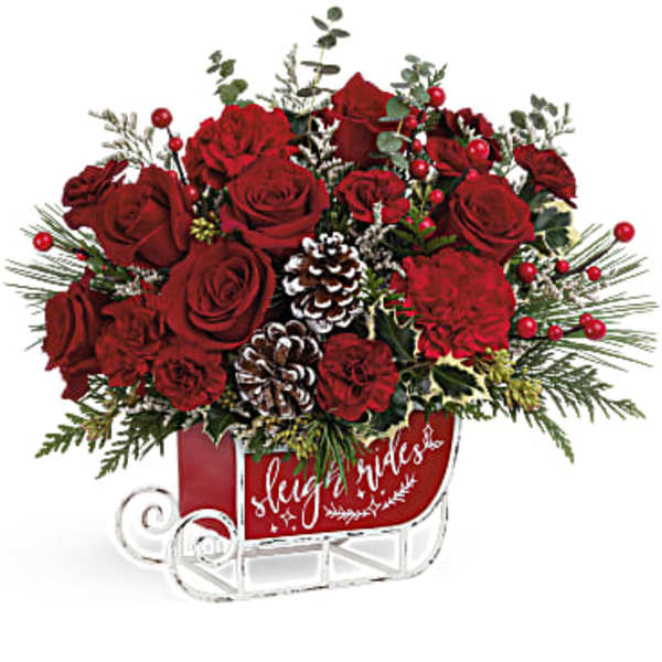 Red roses arranged in a sleigh-shaped container with pinecones and berries