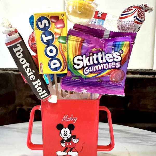 Mickey Mouse candy bouquet in a red container with assorted sweets on sticks