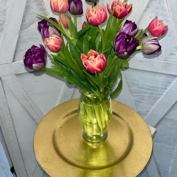 Bouquet of pink and purple tulips in a clear glass vase