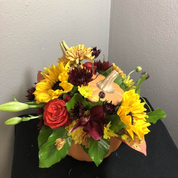Pumpkin-shaped floral arrangement with sunflowers and roses