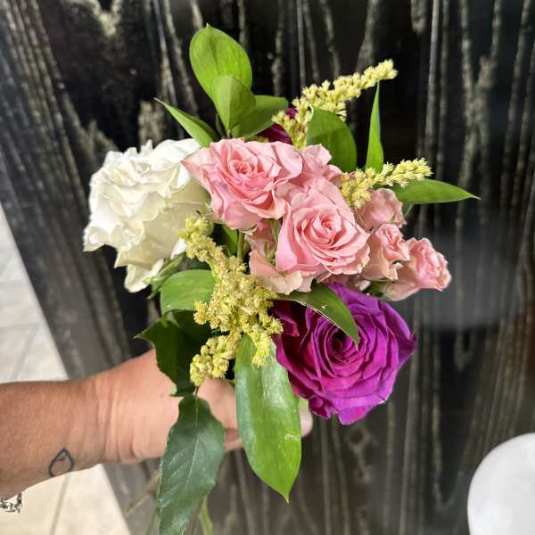 Small hand-tied bouquet of pink, white, and purple roses