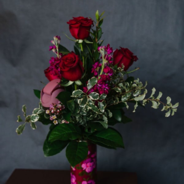 Red roses and pink filler flowers in a floral vase