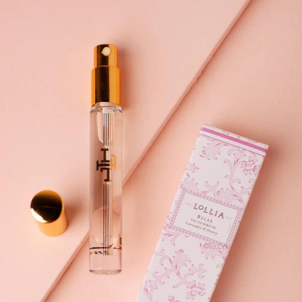 Perfume spray bottle with a pink patterned box on a blush background