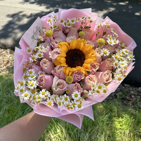 Pink rose bouquet with a sunflower center and white daisies