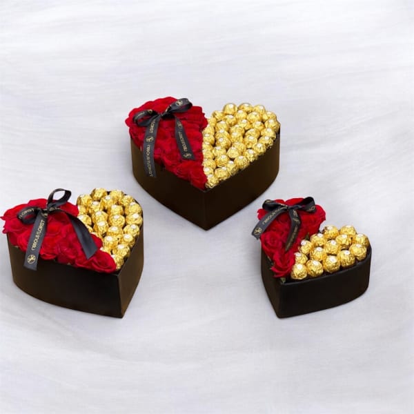 Heart-shaped boxes filled with red roses and gold-wrapped chocolates