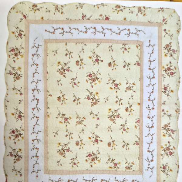 Quilted blanket with small floral print and bordered panels