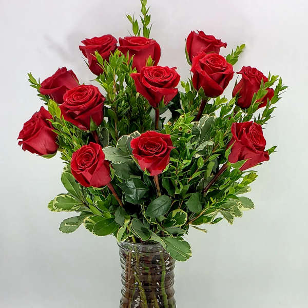 Red roses arranged in a clear glass vase