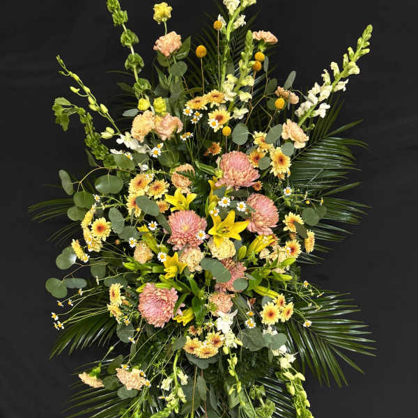Tall floral standing spray with pink, yellow, and white blooms
