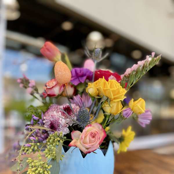Colorful mixed bouquet in a blue egg-shaped container