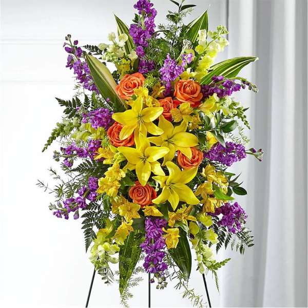 Tall floral spray with yellow lilies, orange roses, and purple flowers