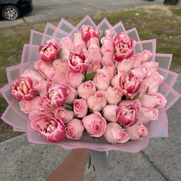Bouquet of pink roses and pink tulips wrapped in pink paper