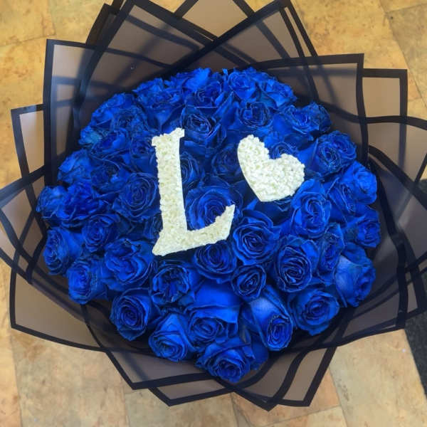 Round bouquet of blue roses with white floral letters and heart
