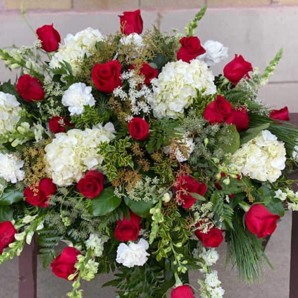 Large red and white floral arrangement with roses and hydrangeas