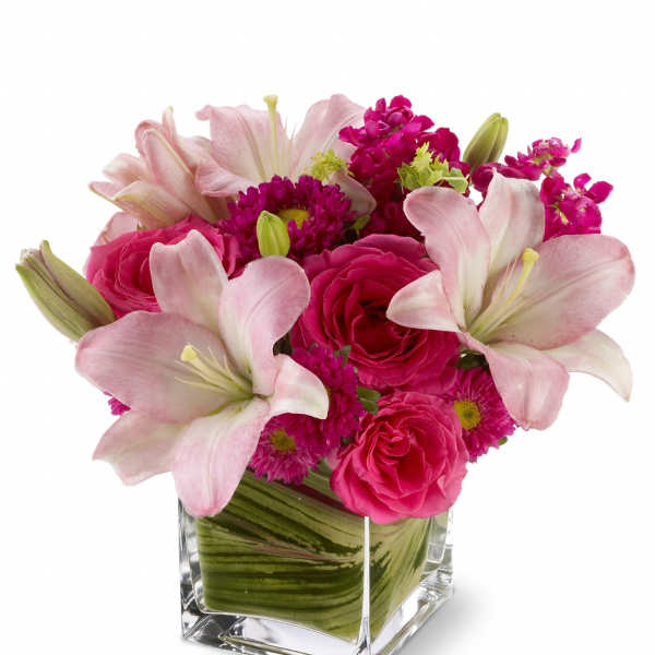 Pink lilies and roses in a square glass vase