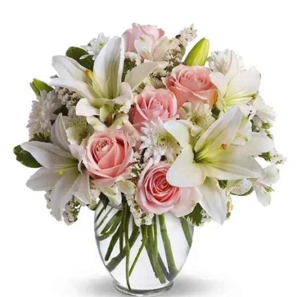 Pink roses and white lilies arranged in a clear glass vase