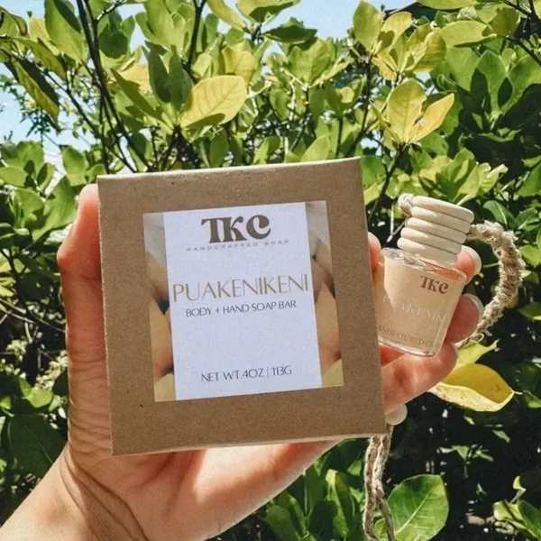 Hand holding a boxed soap bar and a small bottle outdoors