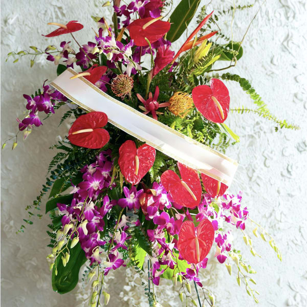 Tropical floral arrangement with red anthuriums and purple orchids