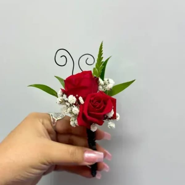 Red rose boutonniere with baby's breath and green leaves