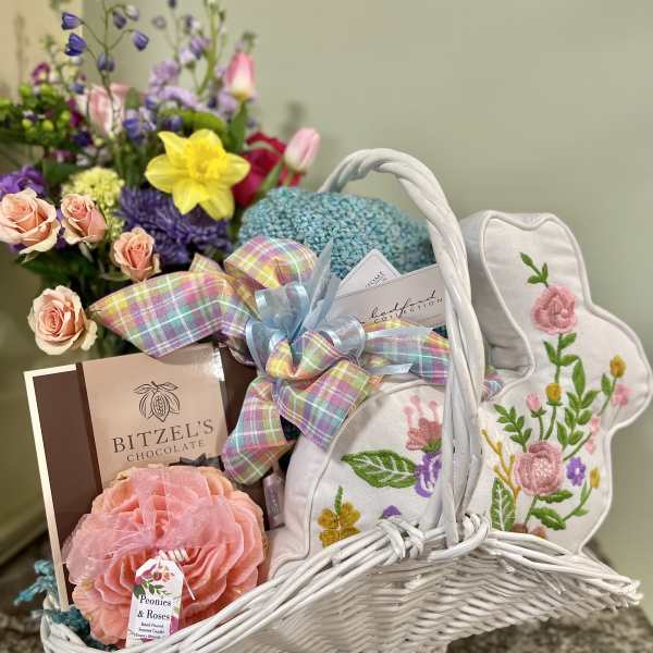 Gift basket with flowers, chocolates, candles, and embroidered bunny decor