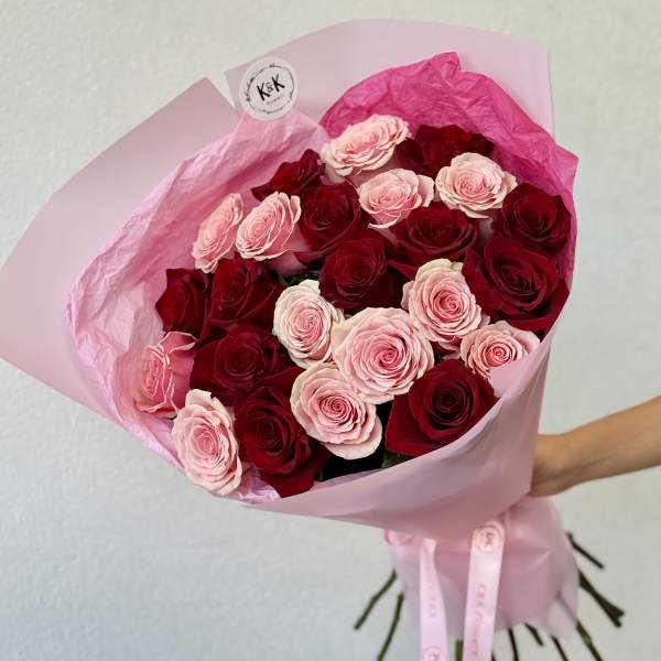 Bouquet of pink and red roses wrapped in pink paper