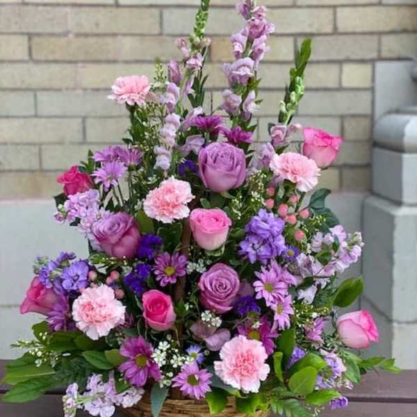 Basket arrangement of pink and purple flowers with tall spikes