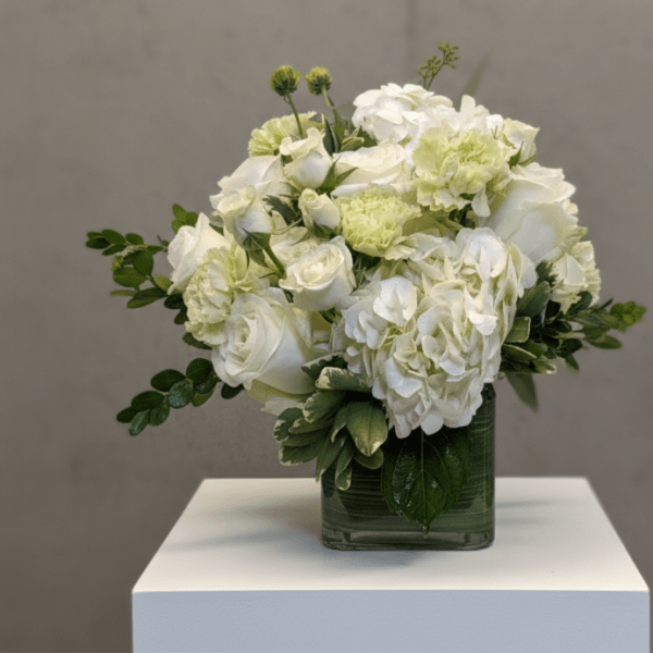 White floral arrangement in a square glass vase