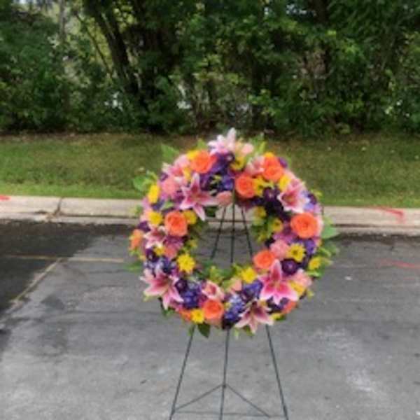 Colorful floral wreath on a metal stand outdoors