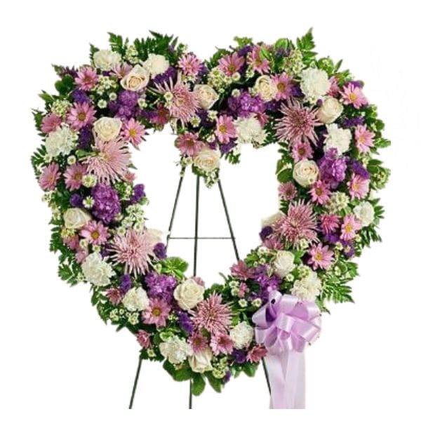 Heart-shaped floral wreath on an easel with a lavender ribbon