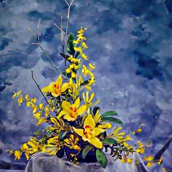 Asymmetrical arrangement of yellow orchids and small yellow blooms in a low black container