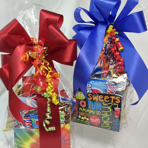 Two gift baskets of assorted candy wrapped with large red and blue bows