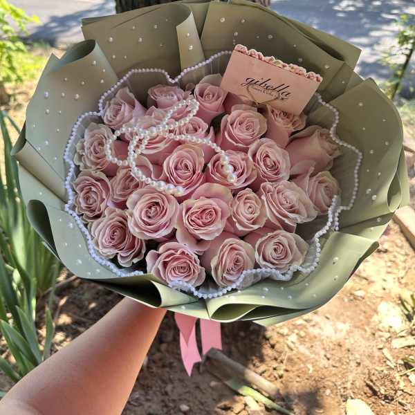 Pink rose bouquet wrapped in sage paper with pearl accents